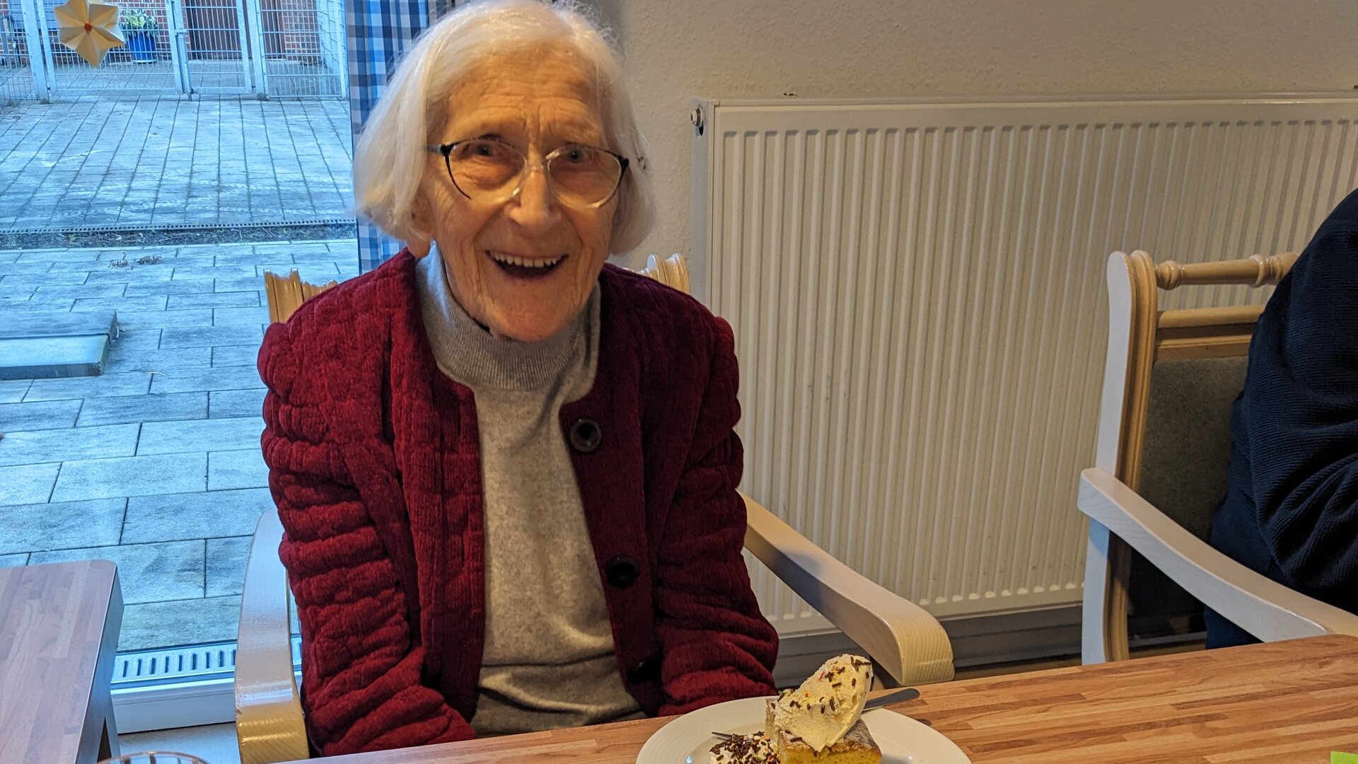 Seniorin am geschmückten Kaffeetisch