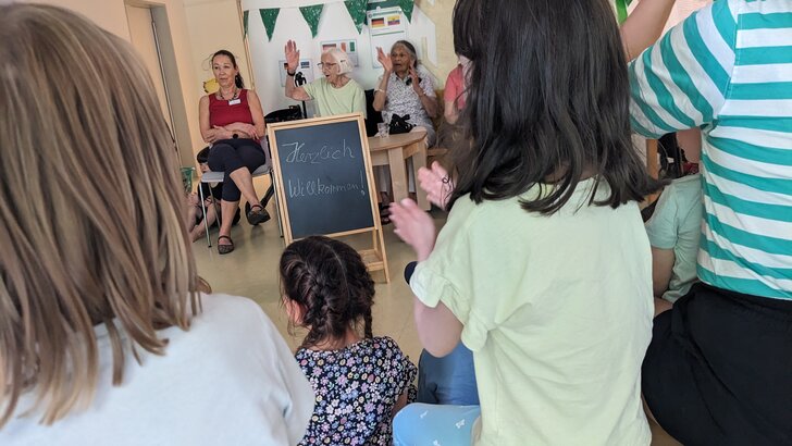 Kinder und Senioren im Stuhlkreis, klatschend